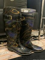 Front view of vintage Ralph Lauren rain boots showing equestrian-themed pattern and buckle straps.
