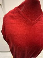 Front and neckline detail of vintage red ESCADA wool and silk V-neck sweater showing fabric texture and color.