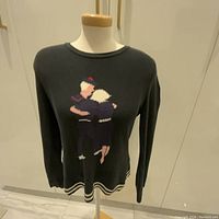 Front view of vintage SONIA RYKIEL sweater on mannequin, showing dancing couple knit design.