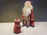 Full view of Santa Claus figure standing with red toy bag.
