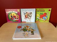 Front view of four children's Christmas books arranged upright and one laid down.