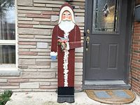Front view of the tall wooden Santa Claus figure showing full length, paint details, and standing base.
