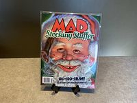 Front cover of MAD Magazine Stocking Stuffer 2022 Reissue showing caricature of Santa Claus with the title and holiday-themed text.