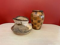 Both vases side by side on table against red background