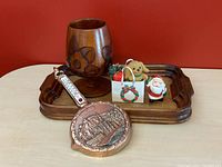 Photo showing carved teak goblet, carved teak tray, copper Dinant wall thermometer, and three Christmas decorations (Santa, gift bag with dog and small wrapped gift).
