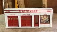 Front view of Plasticville Gas Station with red trim and functional garage doors