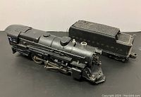 Side angle views of Lionel PRR 675 steam locomotive and Pennsylvania coal tender showing mechanical details and worn areas.