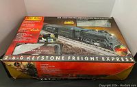 Box front with image of locomotive and caboose, showing 'Keystone Freight Express' set and train names.