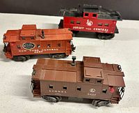 Three vintage Lionel cabooses together, showing overall condition and size relative to each other.