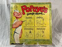 Front cover of the vintage vinyl LP record 'Popeye's Songs About' showing Popeye character and song themes health, safety, friendship, and manners.