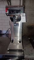 Front view of Bunn CW series industrial coffee maker showing control panel with switches and drip platform.