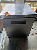 Front view of stainless steel undercounter cooler showing door and ventilation grille
