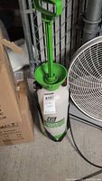 Greenwood 2 gallon garden sprayer showing full view including green handle, top pump mechanism and white tank with green and black label.