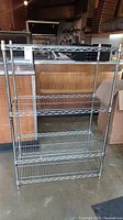 Full front view of the metal wire storage shelf showing all five shelves and the chrome finish.