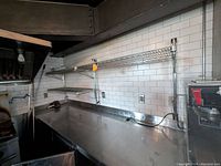 Photo of two wall-mounted wire shelving units above stainless steel countertops in a kitchen environment. Shelves appear sturdy and functional.