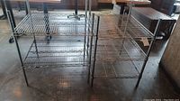 Photo showing two metal wire shelving units side by side on floor.