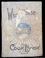 Front cover of the 1925 White House Cook Book showing worn beige cloth binding with black title lettering and circular illustration.