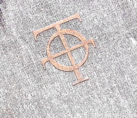 Close-up of grey textured cover with copper/bronze stamped intertwined letters emblem, likely monogram "TO" representing Theatrum Orbis.