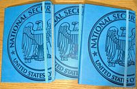 Set of three blue leather covered journals laid out with the front covers showing a large National Security Agency emblem and elastic band closure.