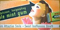 Close-up photo of the vintage Wrigley's Doublemint Gum original advertising poster with text and image of a smiling woman with gum package