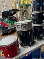 Overview of six drum shells on table outdoors