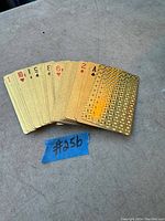 Deck of gold-colored playing cards fanned out to show numbers and design