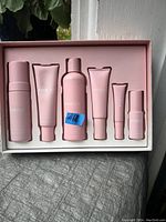 Six pink skincare product containers arranged in white box, labeled Kylie Skin.