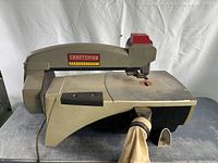 Front view of the scroll saw showing the full body, table, and dust collection bag