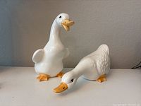 Photo showing both ceramic duck figurines, one upright and one horizontal.