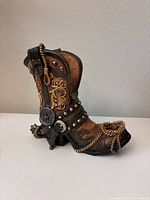 Front and side photo showing the boot's detailed Western design, including a metal star, rivet-studded straps, and rope detail.