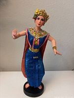 Front view of the resin figurine showing detailed facial features, colorful clothing, and headdress.