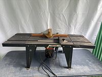 Front view of the Sears Craftsman router table showing the black ridged work surface, adjustable guide rails with wooden fences, and the motor mounted underneath the table frame.