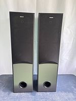 Pair of Sony speakers front view with fabric grills covering the drivers, black top and lower gray section with bass ports.