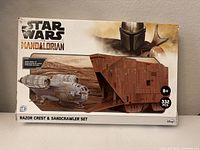 Front of the box showing Star Wars The Mandalorian branding, image of Razor Crest and Sandcrawler models, 332 pcs noted.