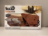 Front of the box showing Star Wars The Mandalorian Razor Crest and Sandcrawler set with piece count 332 and recommended age 8+