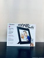 Front view of the Aluratek digital photo frame box showing the product image, brand, and key features including 16GB memory and remote control.