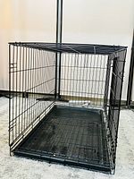 Foldable metal wire pet crate with open side door showing interior and plastic tray