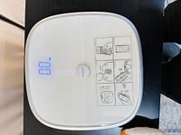 Top view of the Koogeek digital weigh scale with digital display showing zero weight and usage instructions stickers on the surface.