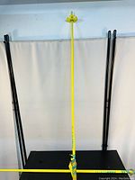 Photo showing three men's ski poles: one yellow with colorful grip and basket, two solid black poles.