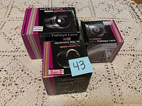 Photo showing two 0.21x fisheye lenses in original boxes (58mm and 37mm) and a Sony 2x Tele Converter in box, with a sticky note labeled 43.
