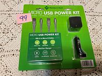 Front view of unopened Micro USB Power Kit packaging showing all included cables and chargers on green backing.