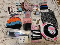 Top view of the full collection spread on a lace cloth including combs, scrunchies, hair ties, bobby pins, and hair claws.