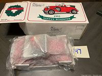 Photo showing the 1992 Santa's Roadster die cast model in unopened plastic wrap inside its original box with branding and decorative label visible.