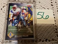 Front of William Fuller football card signed in black marker, card encased in protectve plastic holder.