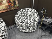 Front view of a swivel tub chair showing white fabric upholstery with black abstract scribble pattern