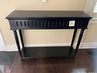 Front view showing overall shape and carved detailing on apron/skirt and legs.