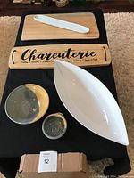 Top view of full set showing the wooden boards, pottery vessels, and ceramic dishes laid out on black fabric.