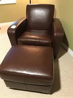 Brown faux leather club chair and ottoman set shown from the front