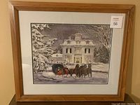 Framed print showing a detailed winter scene with horses and a family in front of a large white house.