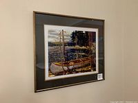 Full view of framed print showing gold-tone wooden frame, double mat, artwork 'The Canoe'